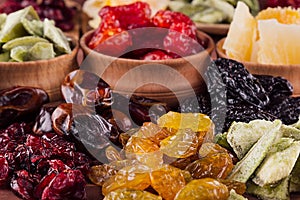 Assortment of dried fruits closeup on brown wooden background.