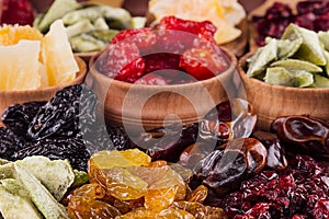 Assortment of dried fruits closeup on brown wooden background.