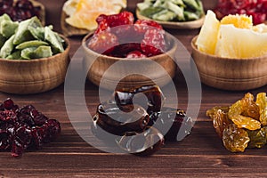 Assortment of dried fruits closeup on brown wooden background.