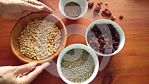 Assortment of dried peas, hemp, flaxe, raisins on wooden table