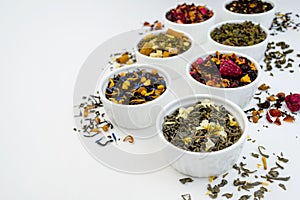 Assortment of dry tea in bowls on white background. Close up macro shot concept. Healthy, organic drink