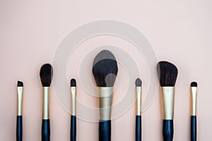 Assortment of female make-up of various face brushes. A set of professional dark blue and golden makeup brushes on a