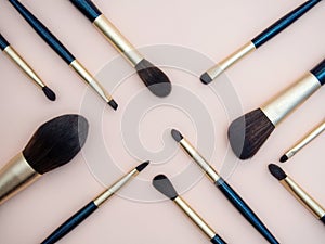 Assortment of female make-up of various face brushes. A set of professional dark blue and golden makeup brushes on a