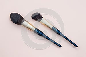 Assortment of female make-up of various face brushes. A set of professional dark blue and golden makeup brushes on a