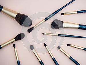 Assortment of female make-up of various face brushes. A set of professional dark blue and golden makeup brushes on a