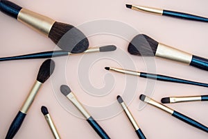 Assortment of female make-up of various face brushes. A set of professional dark blue and golden makeup brushes on a