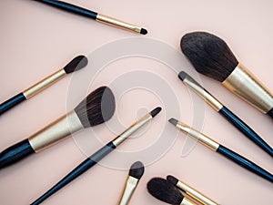 Assortment of female make-up of various face brushes. A set of professional dark blue and golden makeup brushes on a