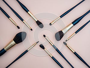 Assortment of female make-up of various face brushes. A set of professional dark blue and golden makeup brushes on a