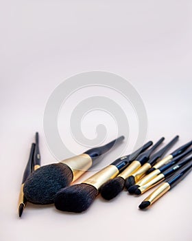 Assortment of female make-up of various face brushes. A set of professional dark blue and golden makeup brushes on a