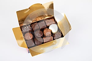 Assortment of fine chocolates candies in small gift gold box of dark milk chocolate