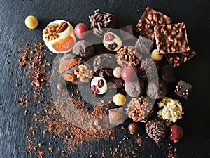 Assortment of fine chocolates in white, dark and milk chocolate on black background