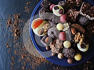 Assortment of fine chocolates in white, dark and milk chocolate on black background