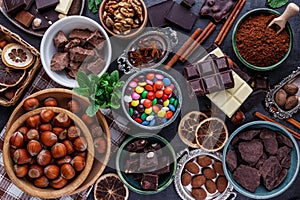 Assortment of fine chocolates in white, dark, and milk chocolate. Broken chocolate pieces. Sweet food photo concept. Top view with