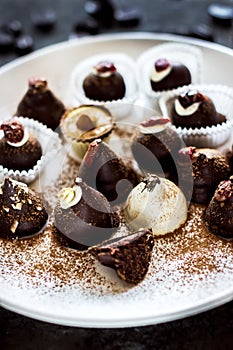 An assortment of fine chocolates in white, dark, and milk chocolate on white plate.