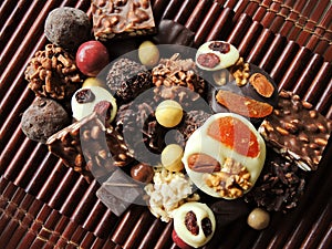 Assortment of fine chocolates in white, dark and milk chocolate on wooden background