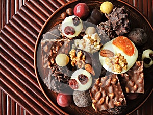 Assortment of fine chocolates in white, dark and milk chocolate on wooden background