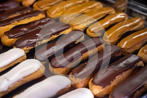 Assortment of french fresh baked eclair sweet pastry  in confectionery shop