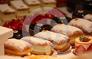 Assortment of french fresh baked sweet pastry with fresh fruits and berries in confectionery shop