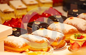 Assortment of french fresh baked sweet pastry with fresh fruits and berries in confectionery shop