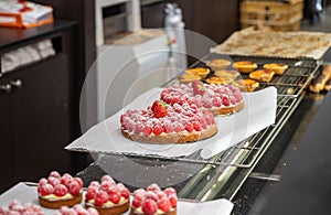 Assortment of french fresh baked sweet pastry with fresh fruits and berries in confectionery shop