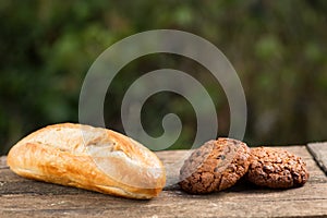 Assortment of fresh baked goods wooden background. baguette and cookies in the open space