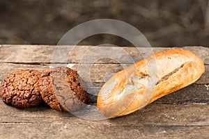 Assortment of fresh baked goods wooden background. baguette and cookies in the open space