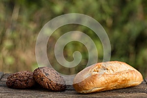 Assortment of fresh baked goods wooden background. baguette and cookies in the open space