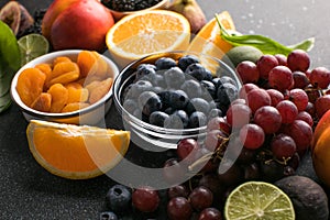 Assortment of fresh exotic fruits and berries on concrete table, flat lay