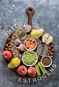 An assortment of fresh foods high in phytoestrogens against a blue background.