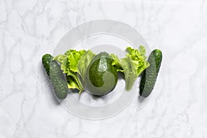 Assortment of fresh green organic vegetables on a marble background