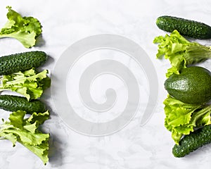Assortment of fresh green organic vegetables on a marble background