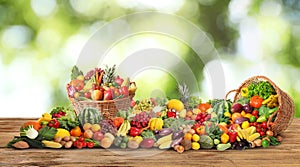 Assortment of fresh organic vegetables and fruits on wooden table against blurred green background. Banner design