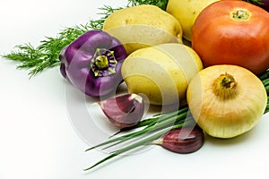 Assortment of fresh raw vegetables on white background. Selection includes potato, tomato, green onion, pepper, garlic