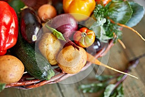 Assortment of fresh vegetables in a basket, bio healthy, organic food on wooden background, country market style, garden produce