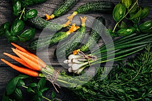 Assortment of fresh vegetables and herbs. Markov, cucumbers, green onions, basil on the table