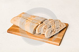 Assortment of freshly sliced baked bread with napkin on rustic table top view. Healthy unleavened bread. French bread