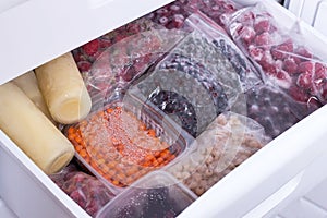 Assortment of frozen berries in plastic bags in the freezer