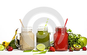 Assortment of fruit and vegetable smoothies in glass jars with straws
