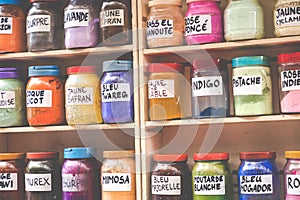 Assortment of glass jars on shelves in herbalist shop on a traditional Moroccan market (souk) in Marrakech, Morocco