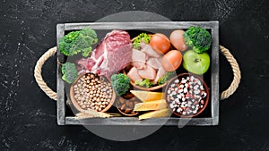 Assortment of healthy protein source and body building foods. Meat, chicken fillet, broccoli, beans, cheese, eggs, wheat.