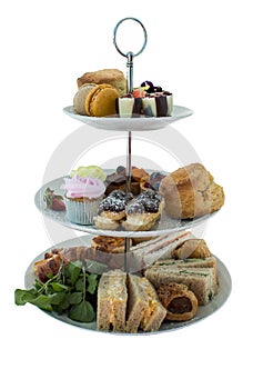 Assortment of high tea delicacies including sandwiches, scones, pies, sweet desserts isolated photo