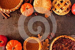 Assortment of homemade autumn pies. Double border on a dark stone background.