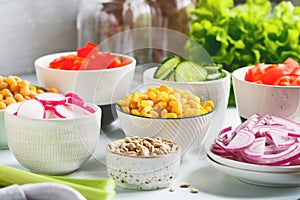 Assortment ingredients for healthy vegetarian salad in different portion bowls on a table