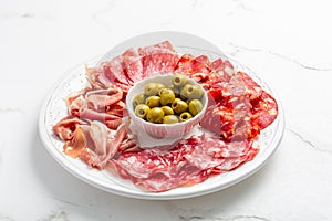 Assortment of Italian and Spanish sliced meat appetizer, prosciutto, salami and ham, with olives