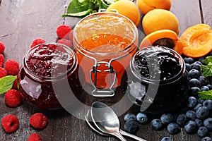 Assortment of jams, seasonal berries, apricot, mint and fruits.