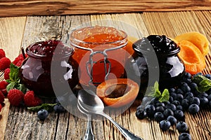 Assortment of jams, seasonal berries, apricot, mint and fruits.