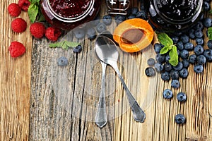 Assortment of jams, seasonal berries, apricot, mint and fruits.