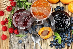 Assortment of jams, seasonal berries, apricot, mint and fruits.