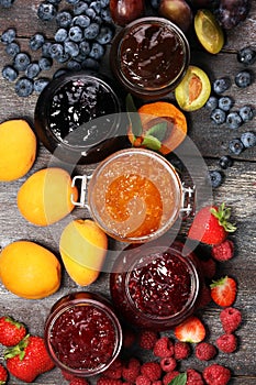 Assortment of jams, seasonal berries, apricot, mint and fruits.