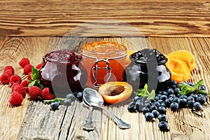 Assortment of jams, seasonal berries, apricot, mint and fruits.